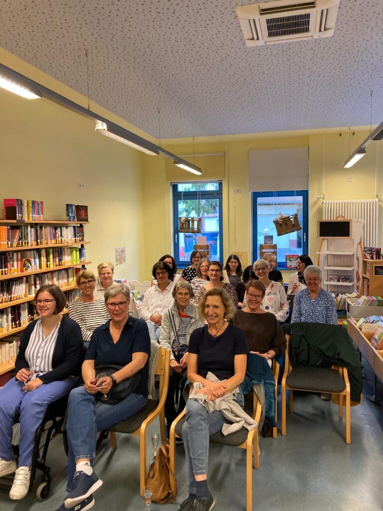Eine Gruppe von Frauen auf Stühlen in einer Bücherei