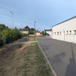 Links die Hecke zum Sportplatz, rechts der Umkleidetrakt mit dem Sportlereingang.