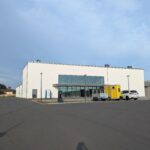 Die neue Halle von Osten aus gesehen. Im Vordergrund die Glasfront vom Foyer. Links der Umkleidetrakt mit dem Sportlereingang.